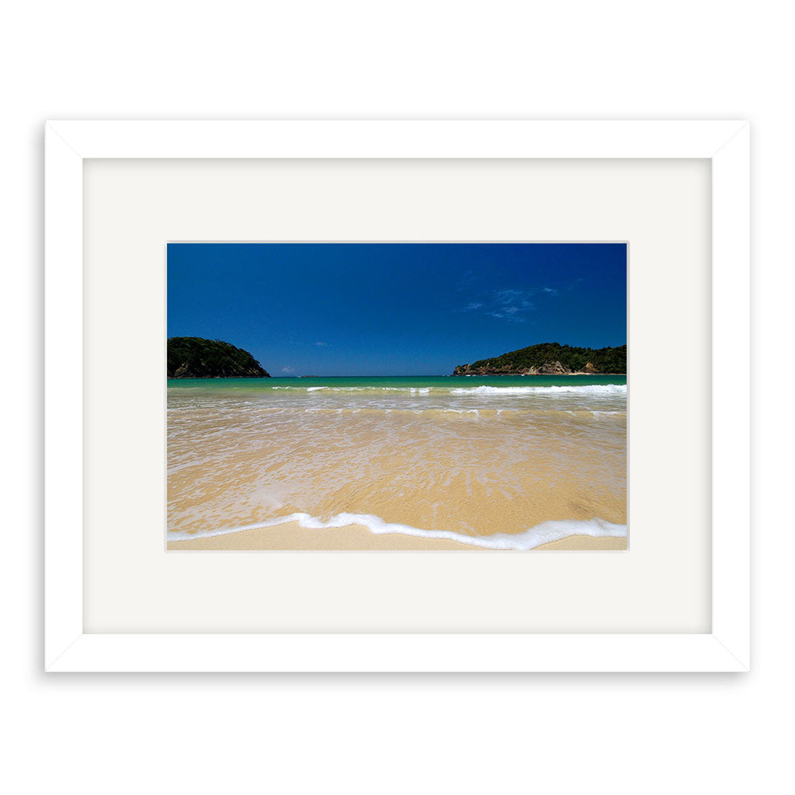 Matapouri - RP034: A framed photo of a beach with light yellow sand, gentle waves, blue-green water, and a deep blue sky. Green hills appear in the distance. Printed on archival quality matte paper for lasting beauty.