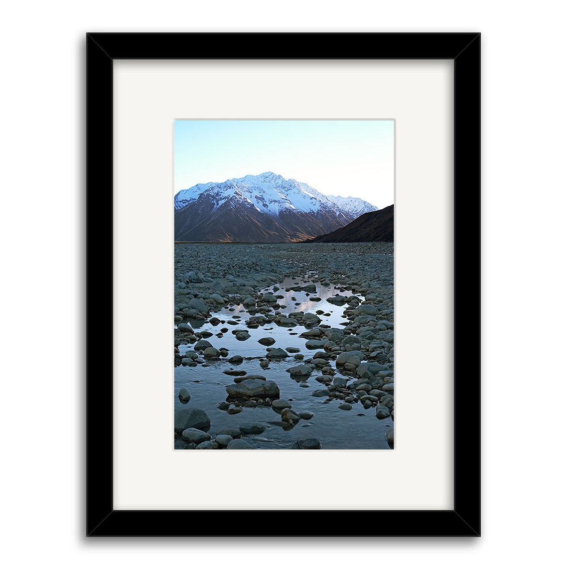 Rangitata River - RP054: A framed photographic print featuring a rocky riverbed and snow-capped mountains under a clear sky, showcasing New Zealands beauty on archival matte paper.