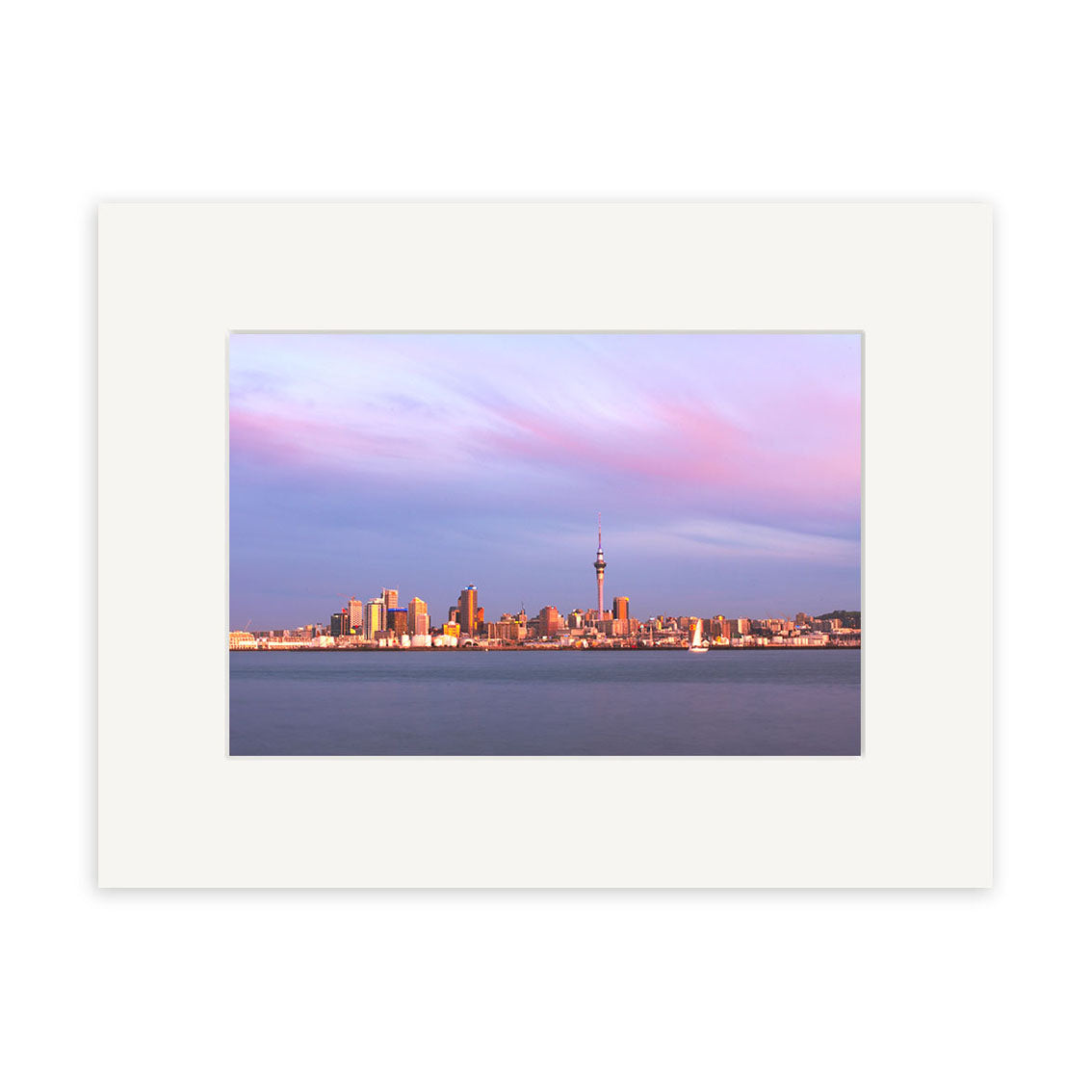 The Auckland Twilight Skyline - RP092 is a framed photographic print of Auckland’s city skyline at sunset, with tall buildings, a prominent tower, pastel purple-pink skies, calm water, and archival-quality craftsmanship for lasting beauty.