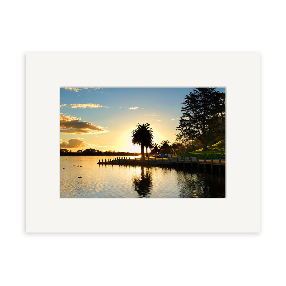 Hamilton Lake - RP097: A framed photo print of a sunset lakeside scene with palm trees, wooden pier, and calm water reflecting golden light. Printed on archival quality matte paper, it beautifully captures tranquility.