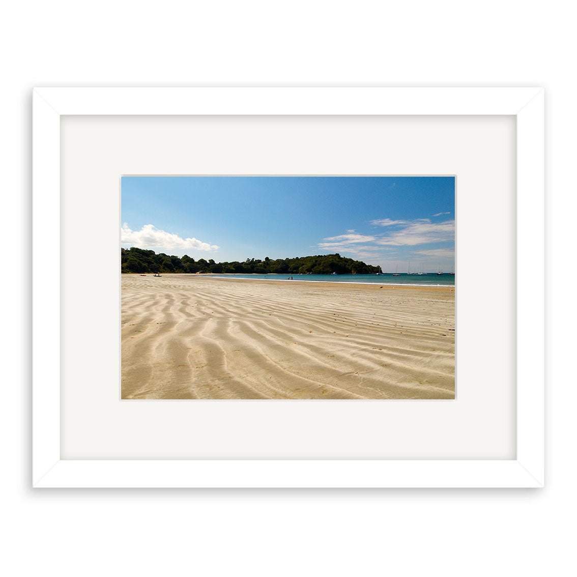 The Oneroa Beach - Waiheke - RP115 framed print captures a sandy New Zealand beach with ripples, calm water, green trees, and a clear blue sky on archival quality paper.