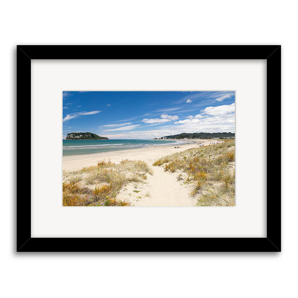 Framed photographic print Whangamata - RP128 features a sandy beach with grassy dunes, distant shoreline figures, and ocean under a blue sky in New Zealand—printed on archival quality matte paper.