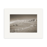 Black and white photograph titled Te Mata Peak - RP132 of a rural New Zealand landscape with a fence along a grassy field toward distant mountains, under a clear sky, framed by a white matte border on archival-quality matte paper.