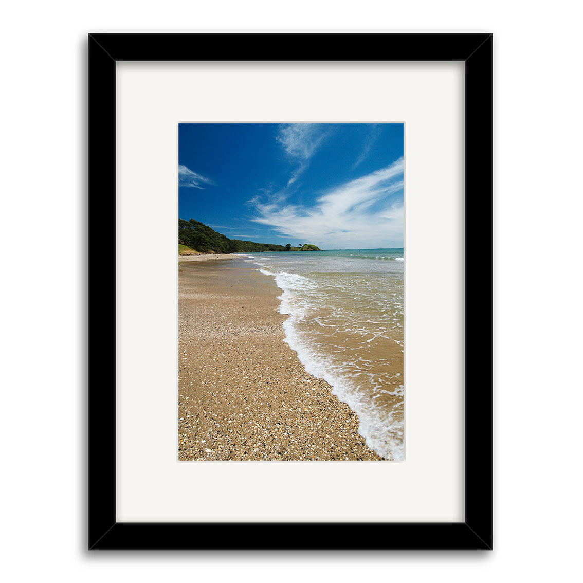 Framed photographic print titled Coopers Beach - RP138 showcases a sandy beach with gentle waves, blue sky, clouds, and greenery along the shore—captured by Reuben Price in New Zealand.
