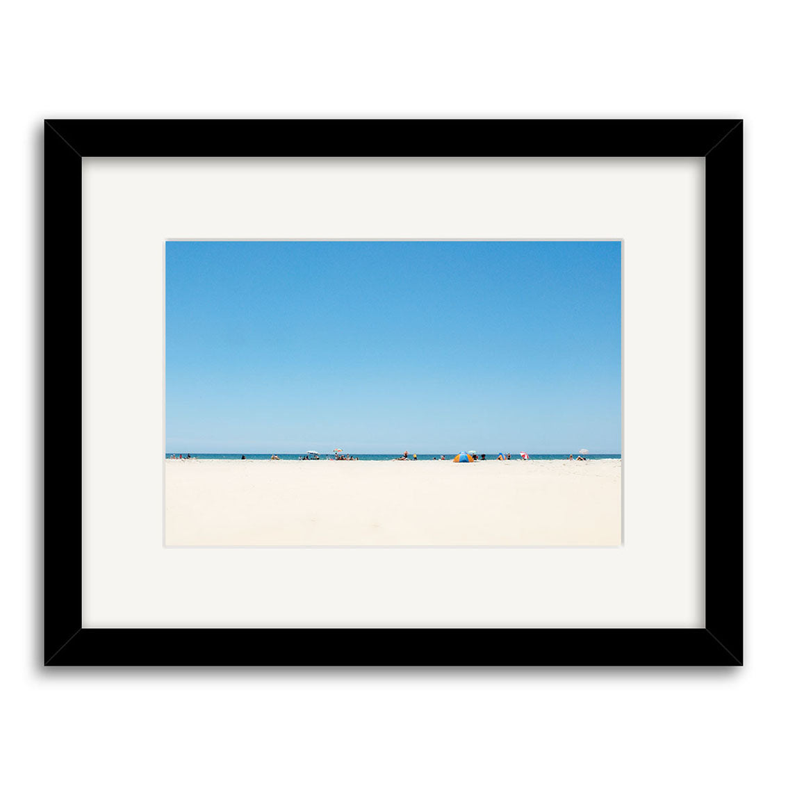 Pakiri Beach - RP142 is a framed photographic print by Reuben Price featuring a minimal New Zealand beach scene with wide sandy foreground, distant figures and umbrellas, and a clear blue sky.