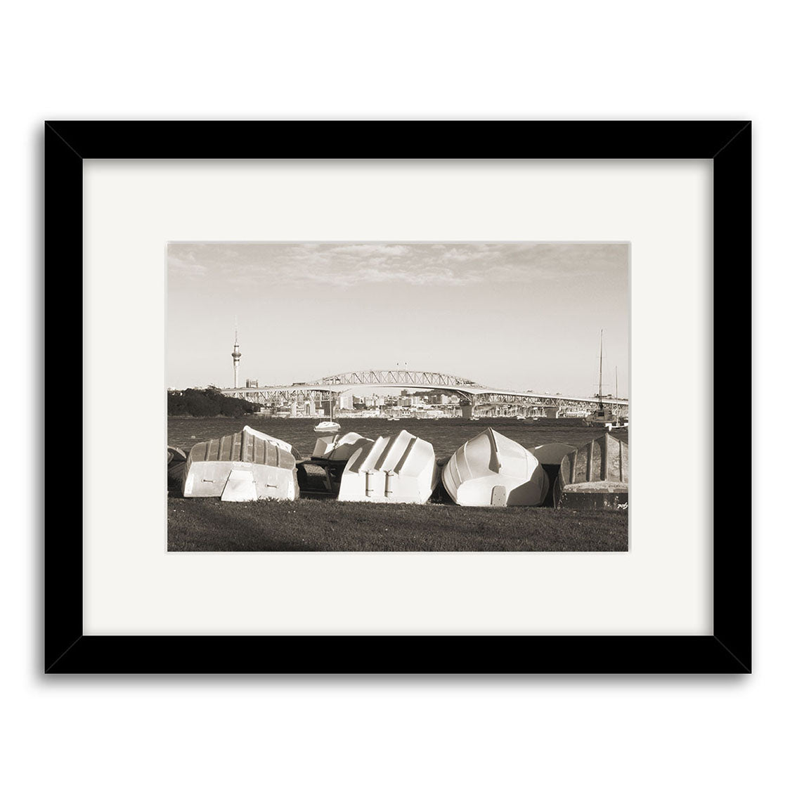 Little Shoal Bay - RP149: A black & white photo in a black frame featuring rowboats on grass with a bridge, city skyline, and tall tower in the background under a partly cloudy sky, printed on archival quality matte paper.