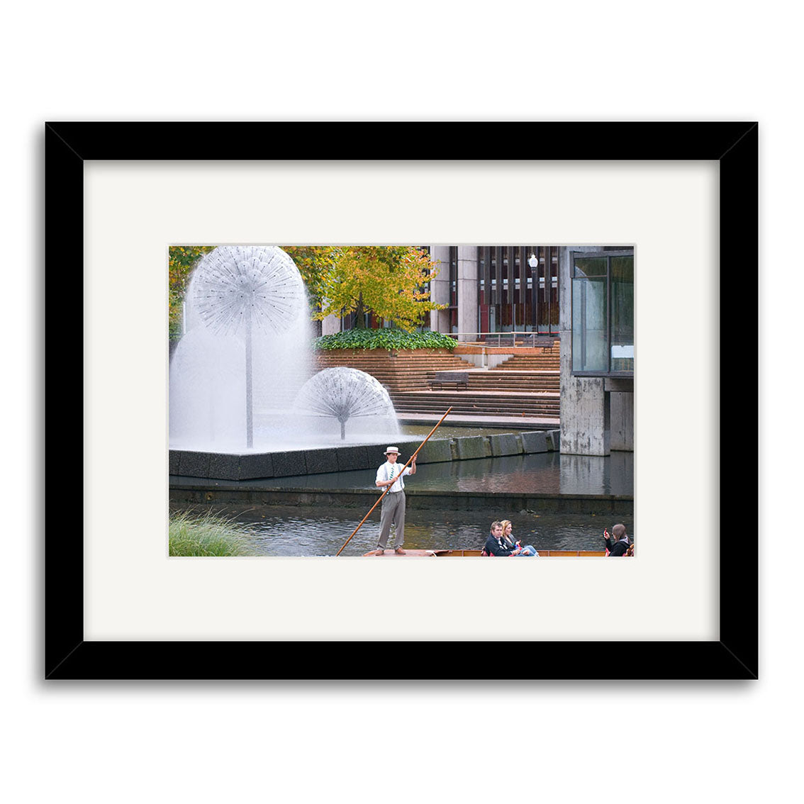 Experience Punting on Avon River - RP171: Glide along the canal with a guide, surrounded by dandelion-shaped water fountains, green and yellow trees, and modern New Zealand buildings in the backdrop.