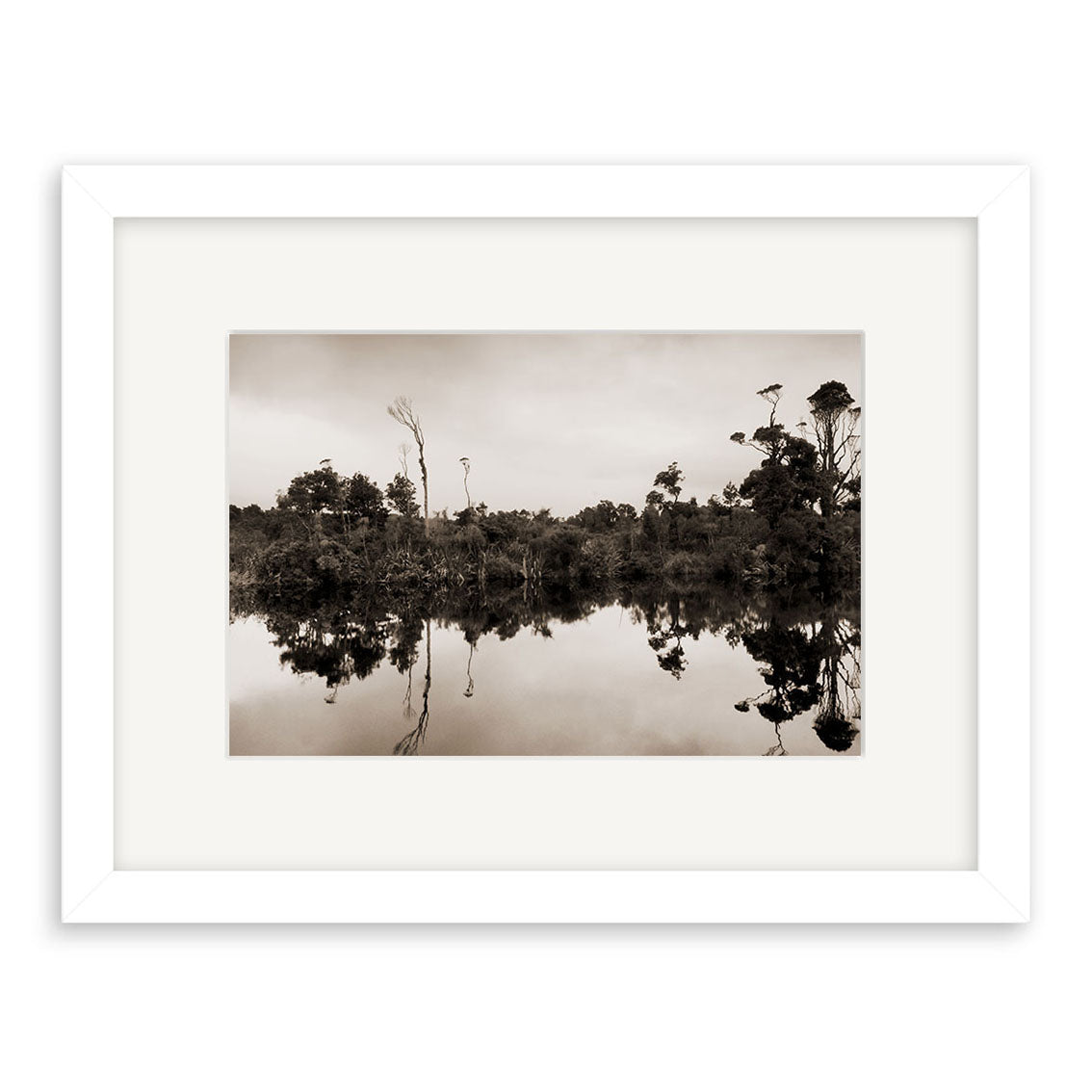 Gillespies Beach Reflections - RP189: A sepia photo of trees mirrored on calm water, framed with a white mat. This tranquil New Zealand scene is printed on archival matte paper, capturing peaceful stillness and minimal movement.