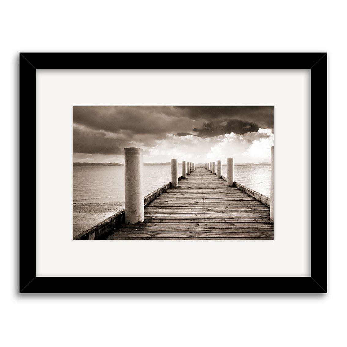 Magazine Bay - RP199 features a framed black-and-white photo printed on archival matte paper, depicting a wooden pier with white posts over calm water beneath clouds. The image is centered in a white mat and sleek black frame.