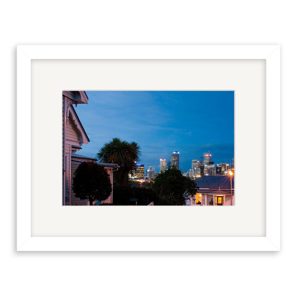 Ponsonby - RP200: Framed photo of suburban houses and trees under a blue evening sky, city skyline in the background. Printed on archival matte paper for lasting beauty—ideal for fine photographic print enthusiasts.