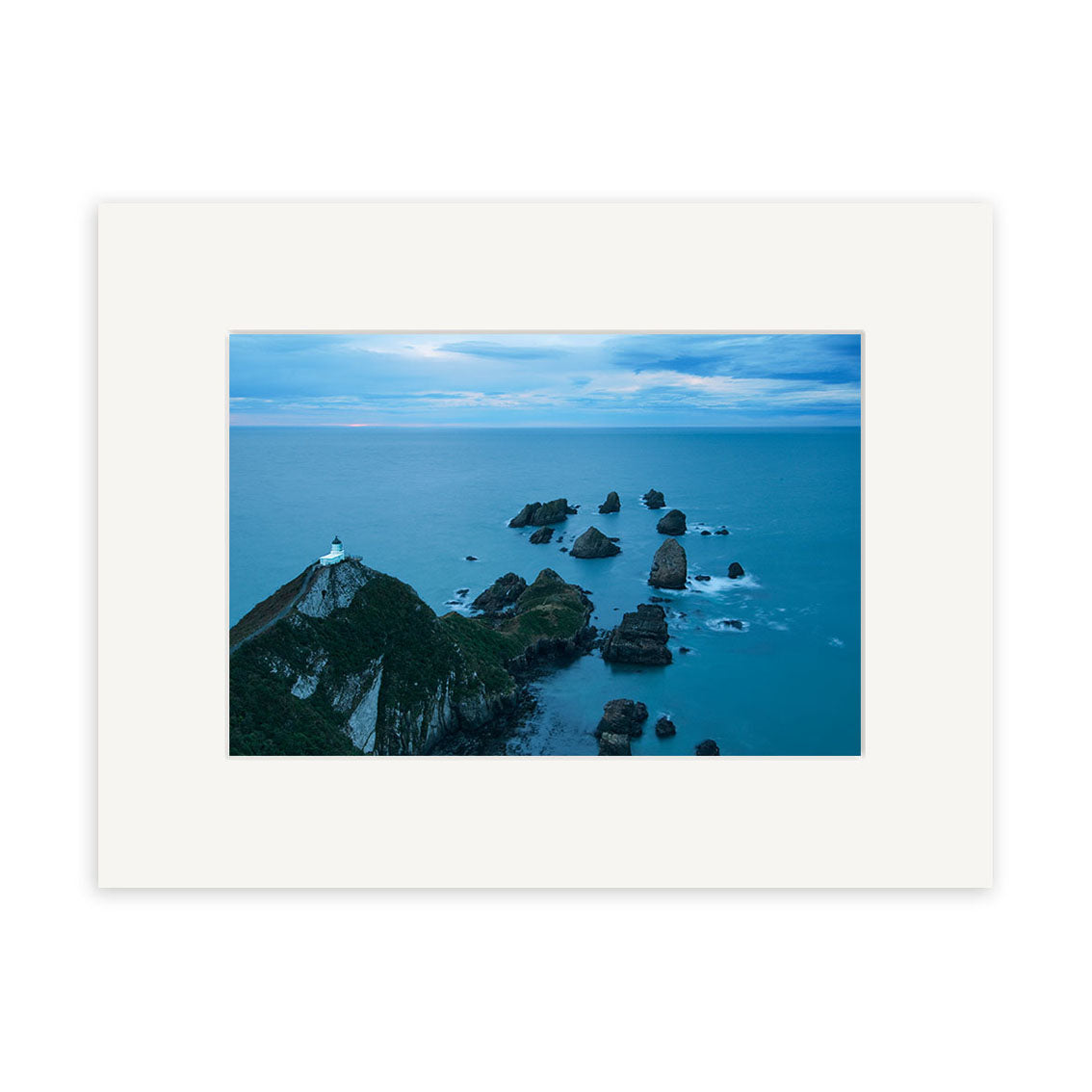 The Nugget Point Caitlins - RP214 is a framed photographic print of a New Zealand coastal landscape with a lighthouse on a green cliff and ocean rock formations, produced on archival quality matte paper.