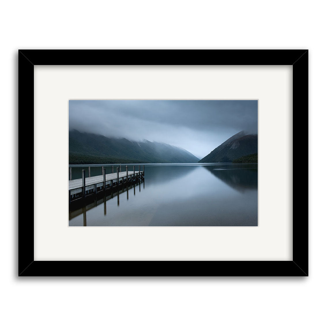 Lake Rotoiti - RP221: A framed photo of a serene New Zealand lake with a wooden dock, mountains, and low clouds reflected on calm water. Printed as archival-quality matte photographic prints.