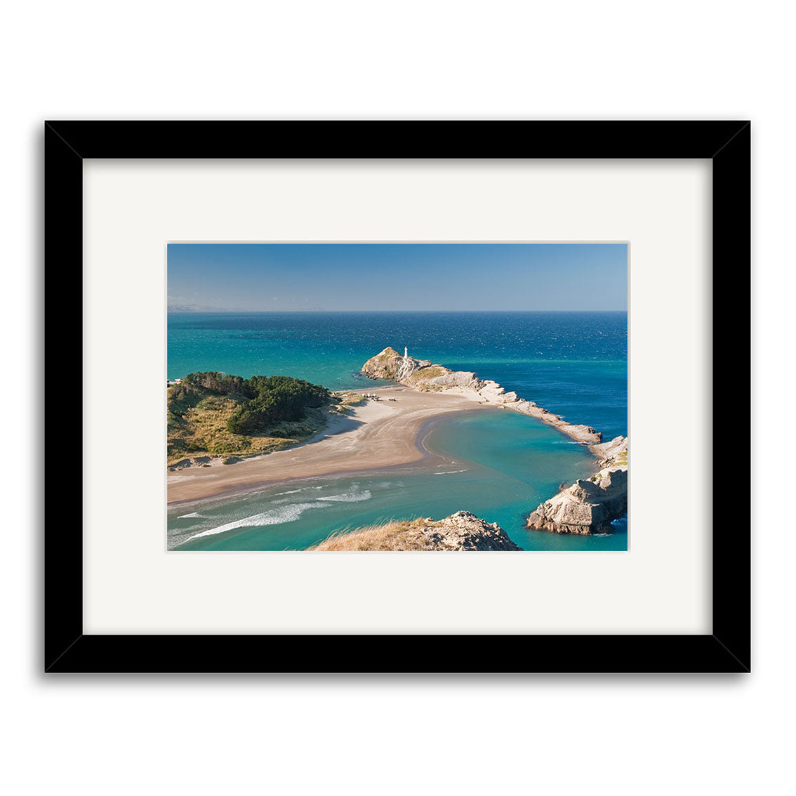 Castlepoint - RP246: Framed photographic print of a New Zealand coastal scene with sandy beach, curved shoreline, and lighthouse on rocks. Features blue ocean under clear sky. Printed on archival quality matte paper for lasting beauty.