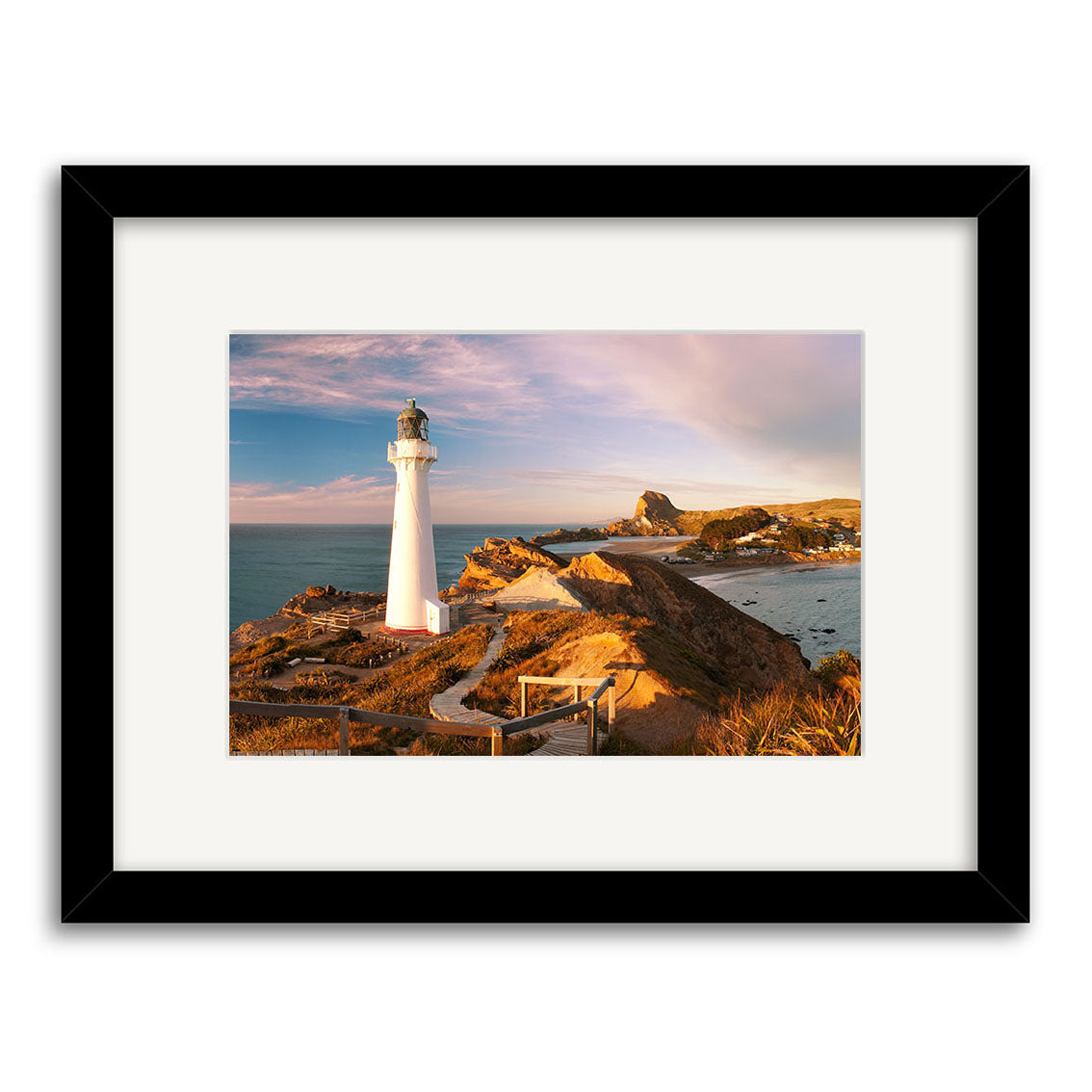 Castlepoint Lighthouse - RP247: A framed photographic print of a white lighthouse on a rocky New Zealand coast, sunny steps and dry grass in the foreground, blue sky above—all beautifully printed on archival quality paper.