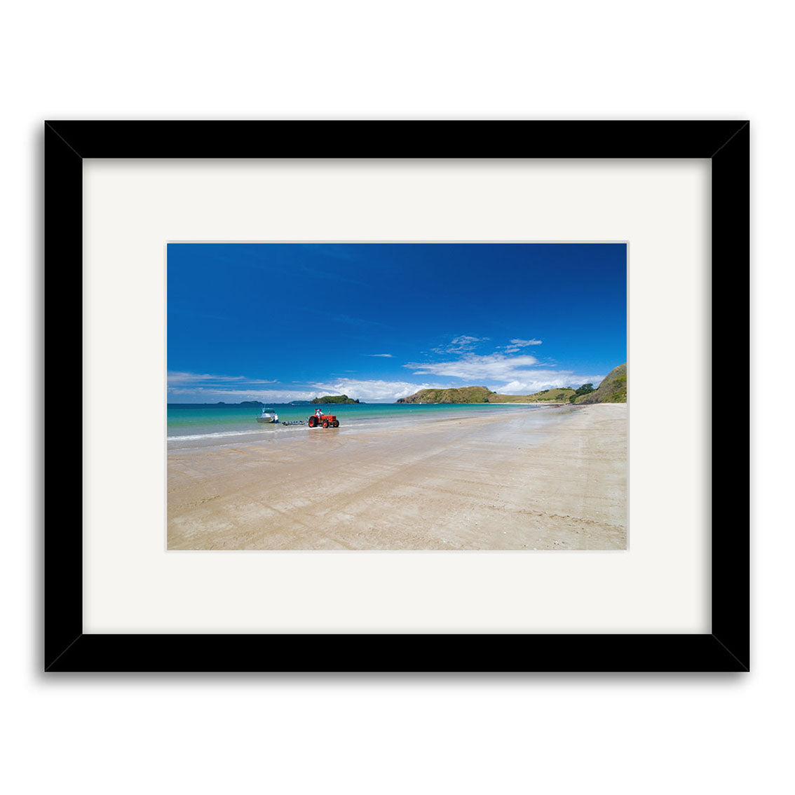 Opito Bay - RP254: Framed photo of a sandy New Zealand beach with blue sky, boat on the water, ATV on shore, and rocky hills in the background. Printed on archival quality matte paper for lasting beauty.