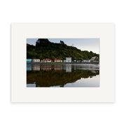 Tongaporutu Baches - RP258 captures small houses along the shore before a forested hill, their reflections in calm water—a classic New Zealand scene ideal for archival quality matte photographic prints.
