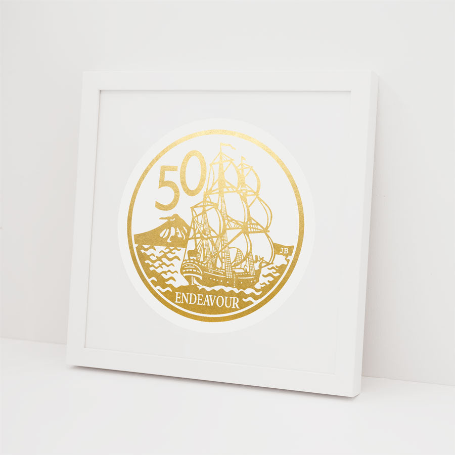 The 50 Cent Coin Foil Print features a sailing ship labeled ENDEAVOUR with the number 50 above it, in gold foil on a plain white background. Available framed or unframed, its inspired by classic Kiwiana and resembles a coin.