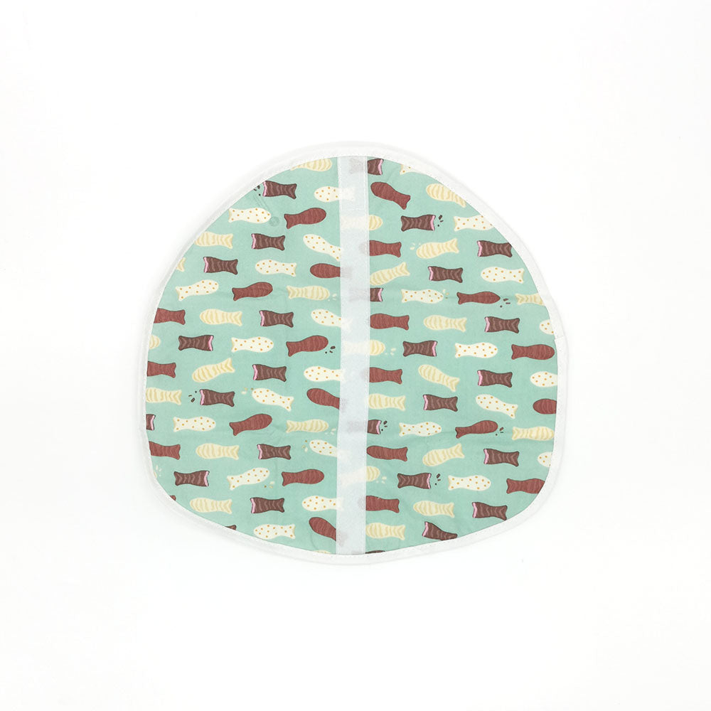The Chocolate Fish Lunch Wrap is a circular, food-safe fabric wrap with a light green background, brown, beige, and cream fish pattern, white trim, and a vertical center seam. Eco-friendly and certified for safe food use.