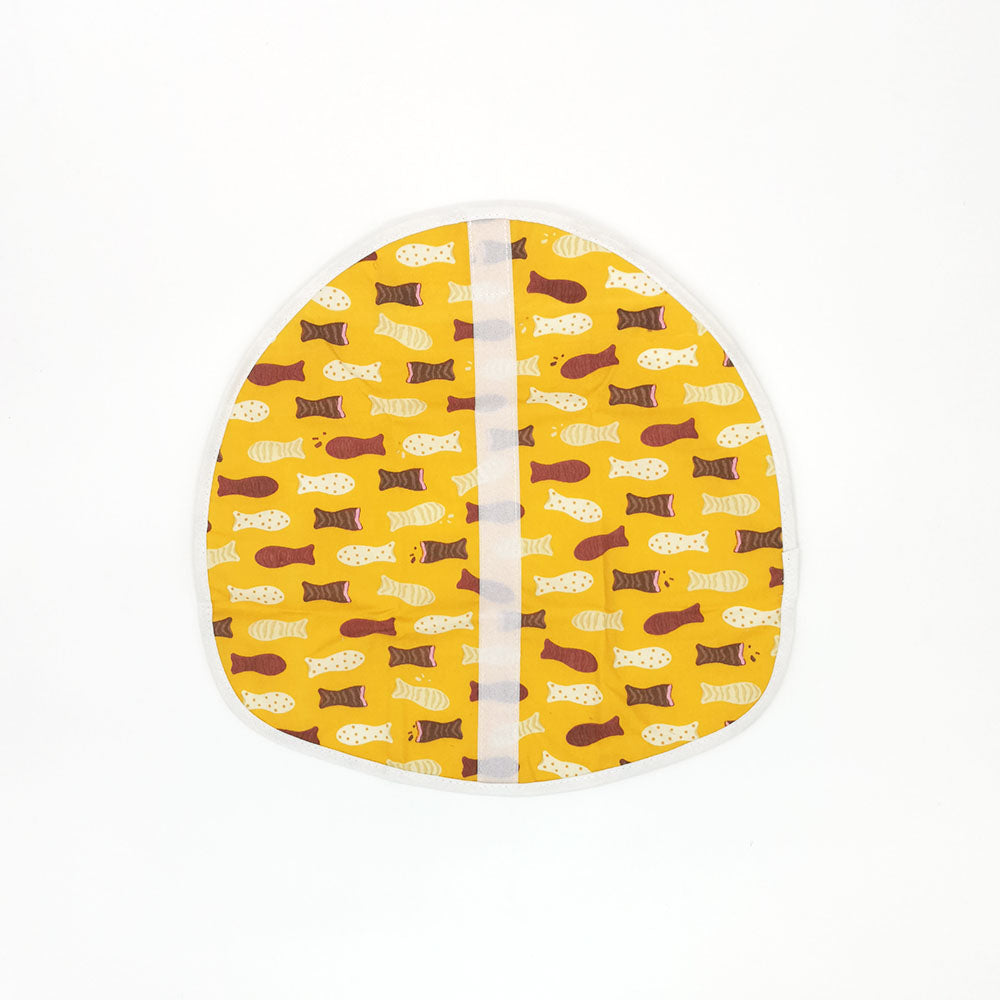 The Chocolate Fish Lunch Wrap is a yellow, semi-circular fabric with brown, cream, and yellow fish patterns, a vertical white seam and border. Eco-friendly and reusable, its perfect for lunch. The background is plain white.