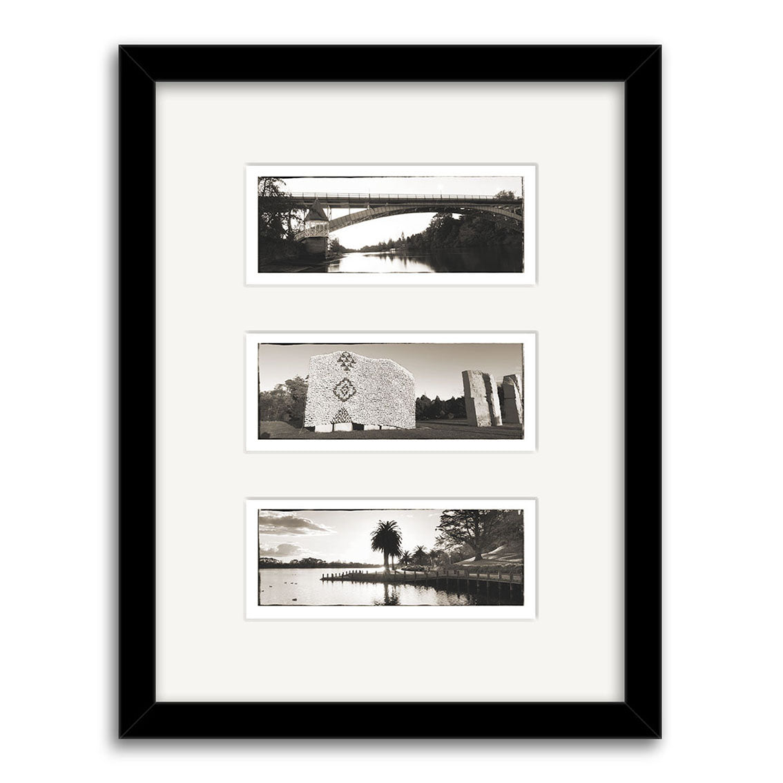 The Hamilton Triptych - RP095 features a black frame with three vertically arranged black-and-white New Zealand prints by Reuben Price on archival matte paper, showcasing a bridge, monument, and waterfront scene with trees and a palm.