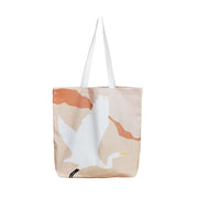 The Modern Kotuku Tote Bag is a beige cotton tote with white handles, showcasing a New Zealand Kotuku (white crane) in flight and bold orange abstract accents—perfect as a unique gift.
