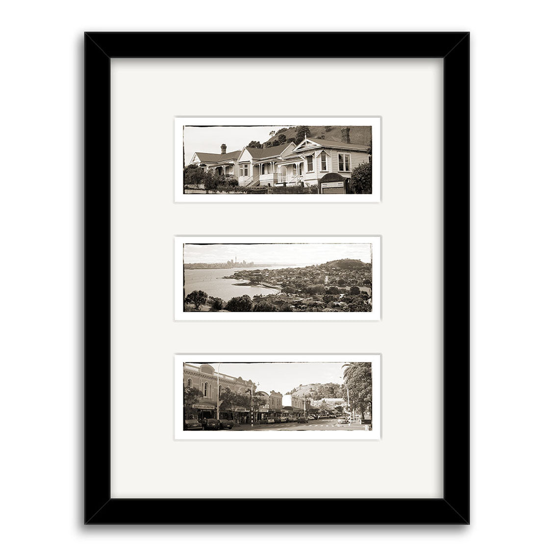 The Devonport Triptych - RP021 features a black-framed display of three sepia-toned photographic prints on archival matte paper: New Zealand houses at the top, a waterfront cityscape in the middle, and a tree-lined street at the bottom.
