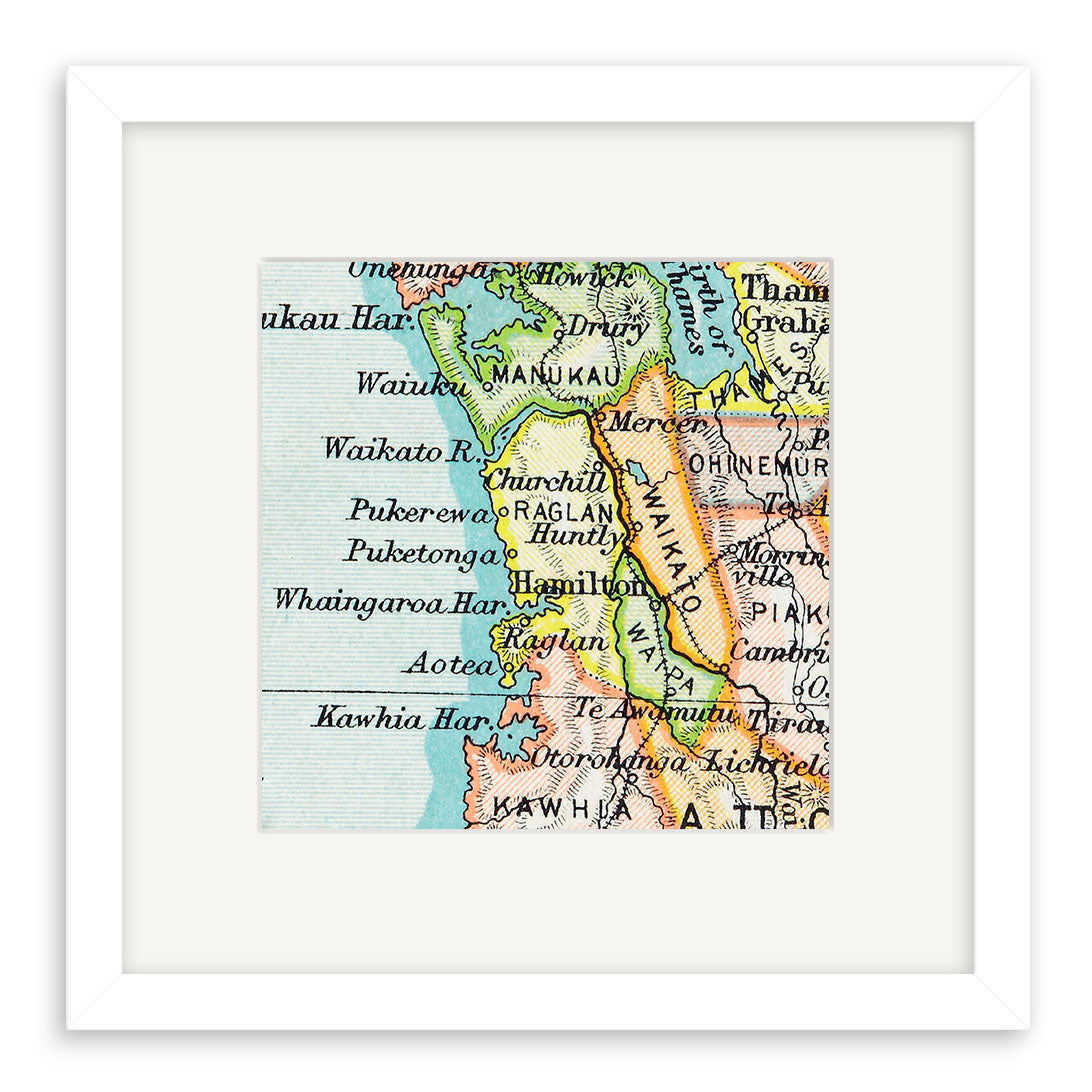 The Raglan Vintage Map Print is a framed 19th-century lithograph giclee showing Waikato, Raglan, Huntly, Hamilton, and nearby North Island areas in black text on a pastel background.