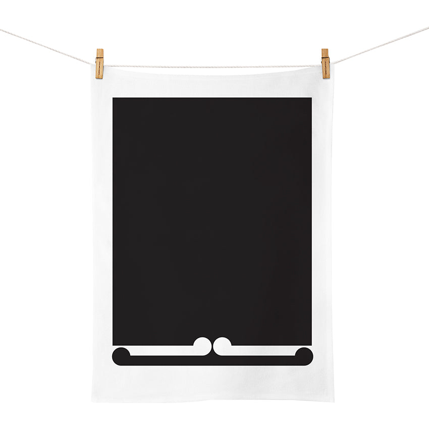 The Gordon Walters - Untitled 1973 Tea Towel, designed in New Zealand, is a white cotton towel featuring a bold black rectangle with a decorative white scroll along the bottom edge, inspired by Gordon Walters’ iconic style.