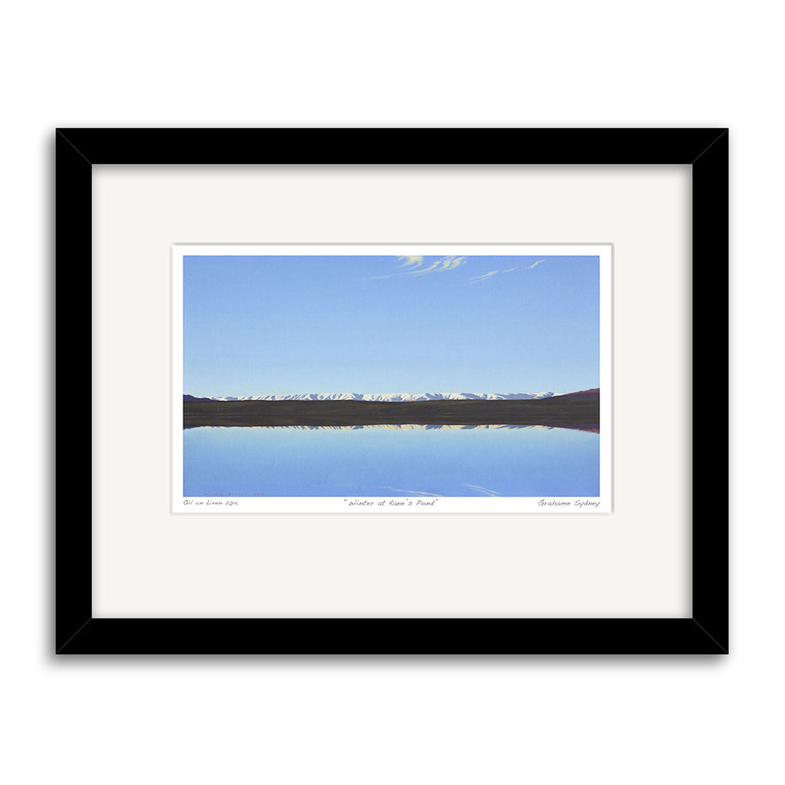 The Grahame Sydney - Winter at Kanes Pond Small Art Print features a tranquil lake reflecting snow-capped mountains and a clear blue sky, reminiscent of his iconic style, and comes displayed with a white mat and black frame.