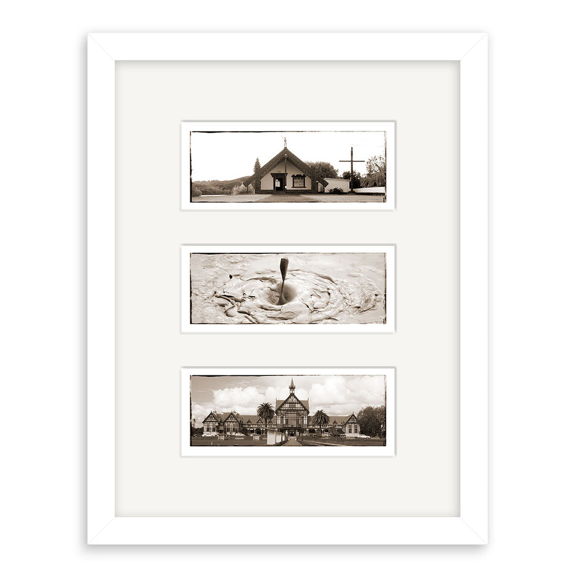 The Rotorua Triptych - RP035 features three sepia-tone prints of New Zealand—a small church, a bubbling mud pool, and a Victorian-style building with palms—vertically arranged in white matting within a white frame.