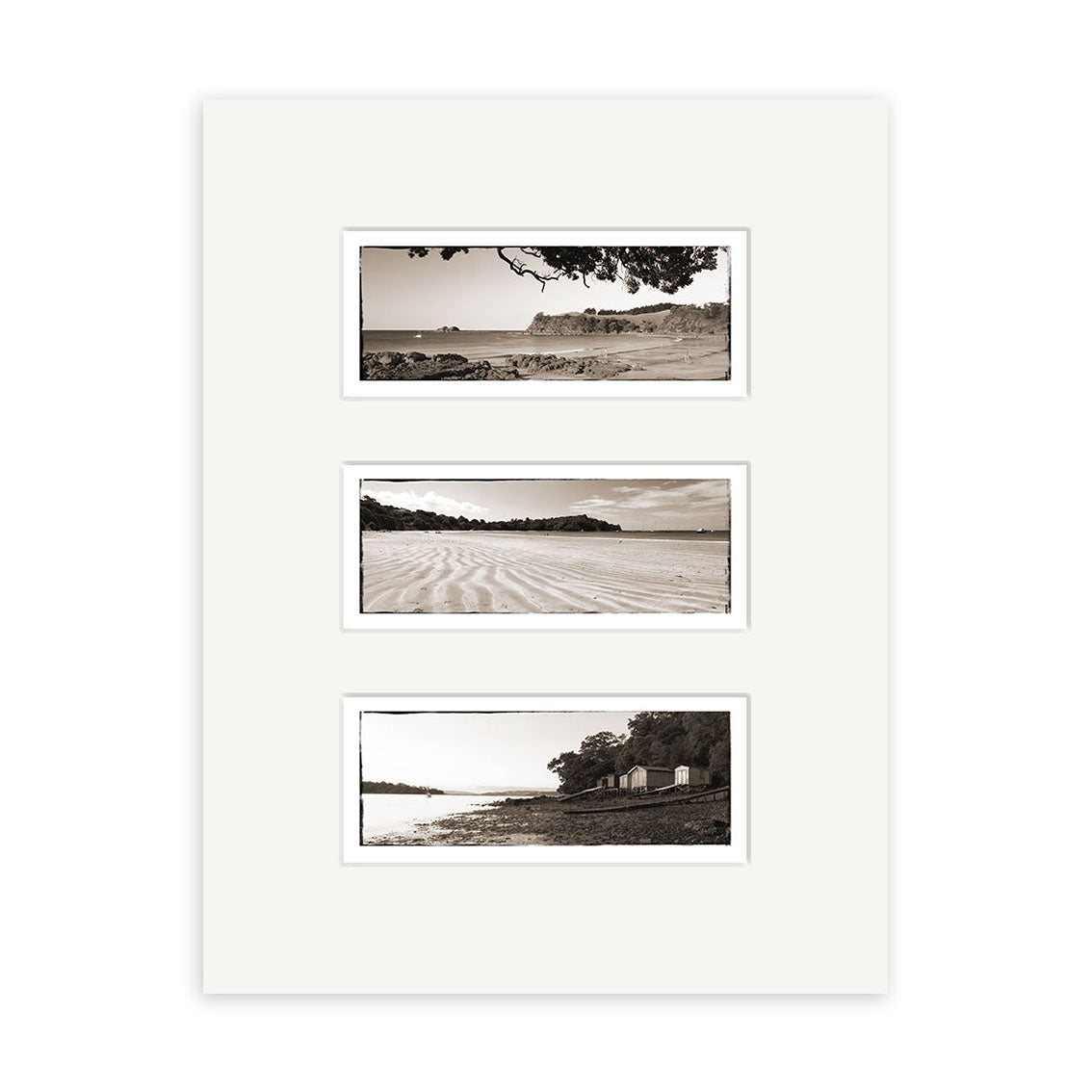 The Waiheke Triptych - RP117 features three black and white New Zealand beach photographs stacked vertically on a white mat, each depicting sand, water, trees, and buildings. Printed on archival quality matte paper.