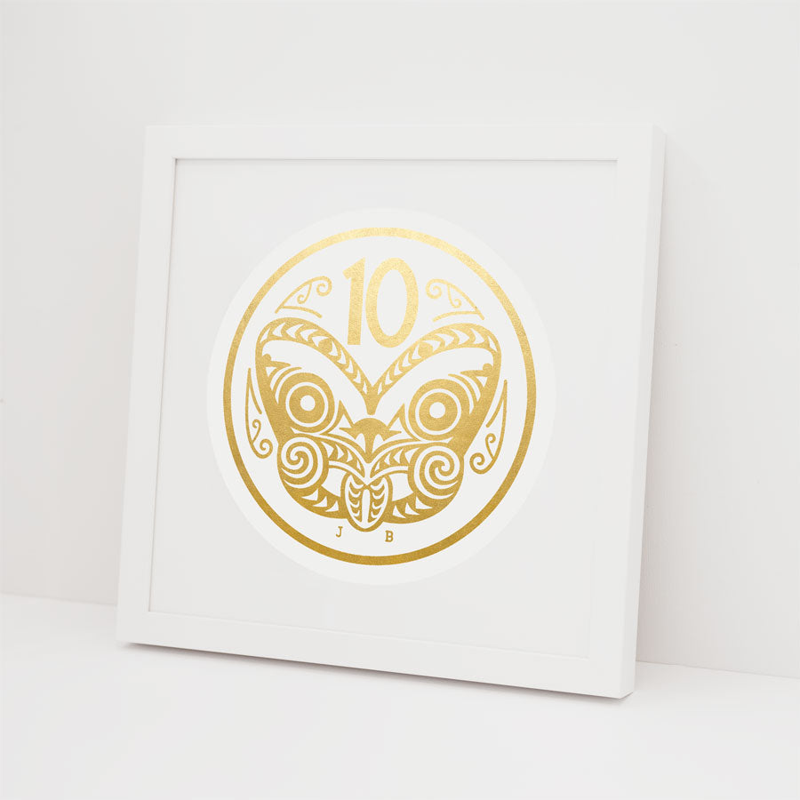 The 10 Cent Coin Foil Print features a gold circular design with the number 10, an intricate symmetrical pattern, and the initials J B on a white frame. Made in New Zealand, it’s ideal for fans of gold foil artwork.