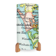 The Vintage Auckland Map Table Lamp features a cylindrical shade with a full-color map of Auckland and nearby regions, place names, bodies of water, wooden legs, and an in-line on/off switch for convenience.